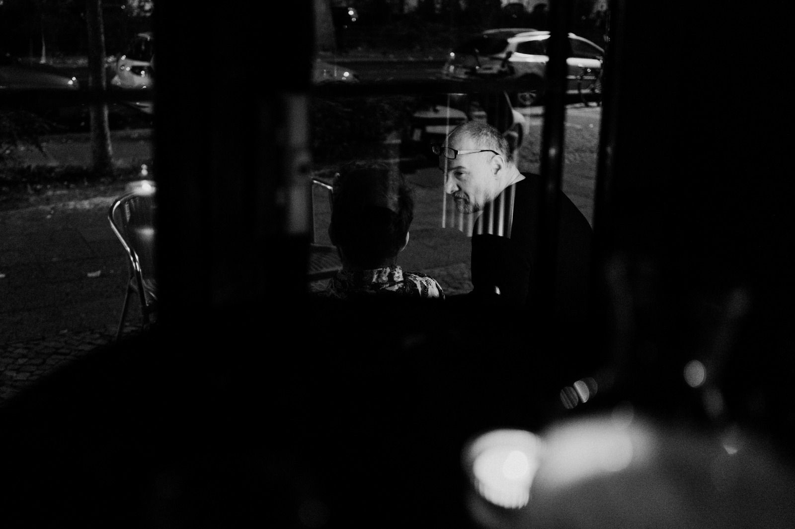 Blick durch das Fenster auf zwei Gäste vor der Bar